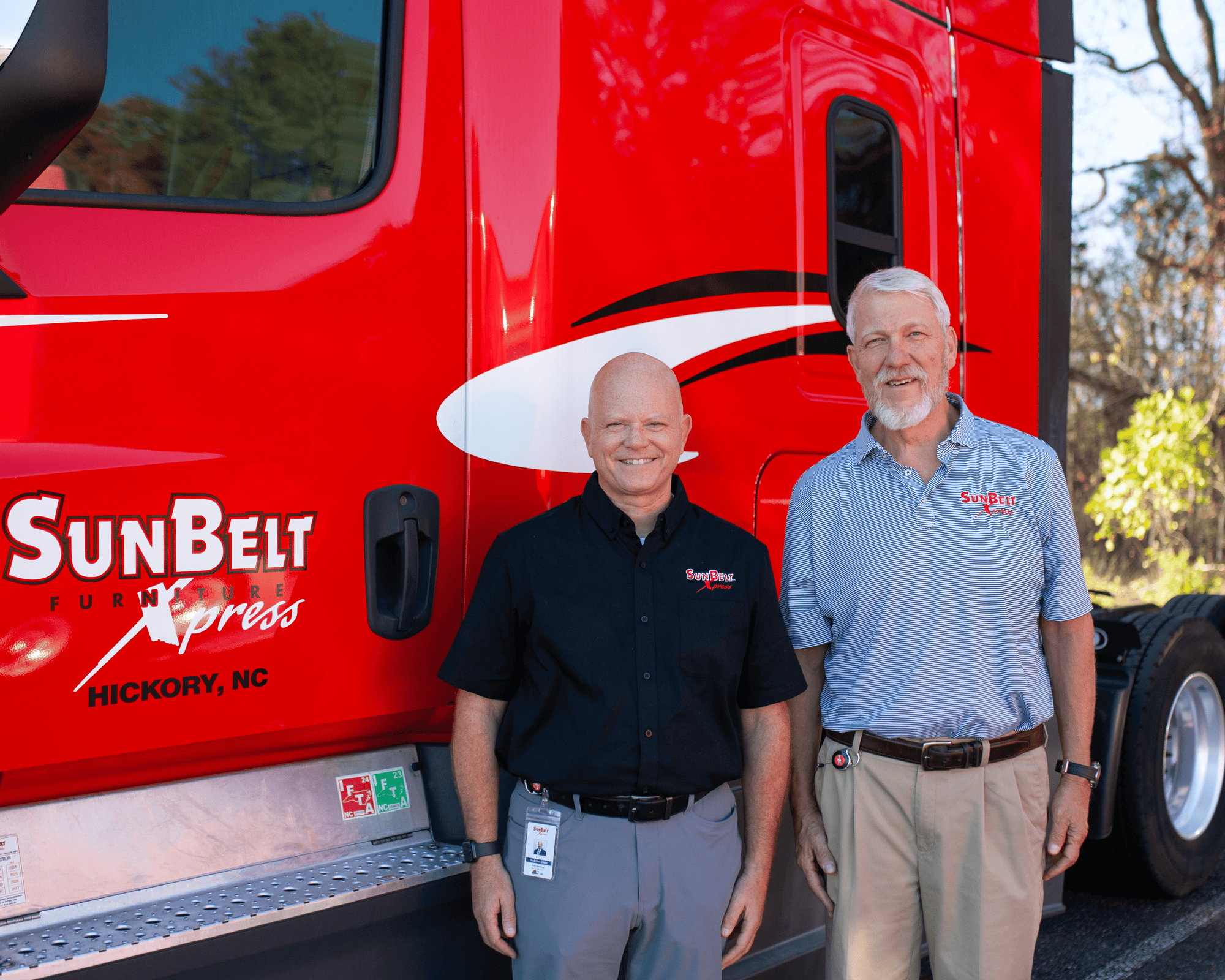 Two men, Chad Clark and Brent Kiser, pose next to a semi truck, representing Sunbelt Xpress's leadership.