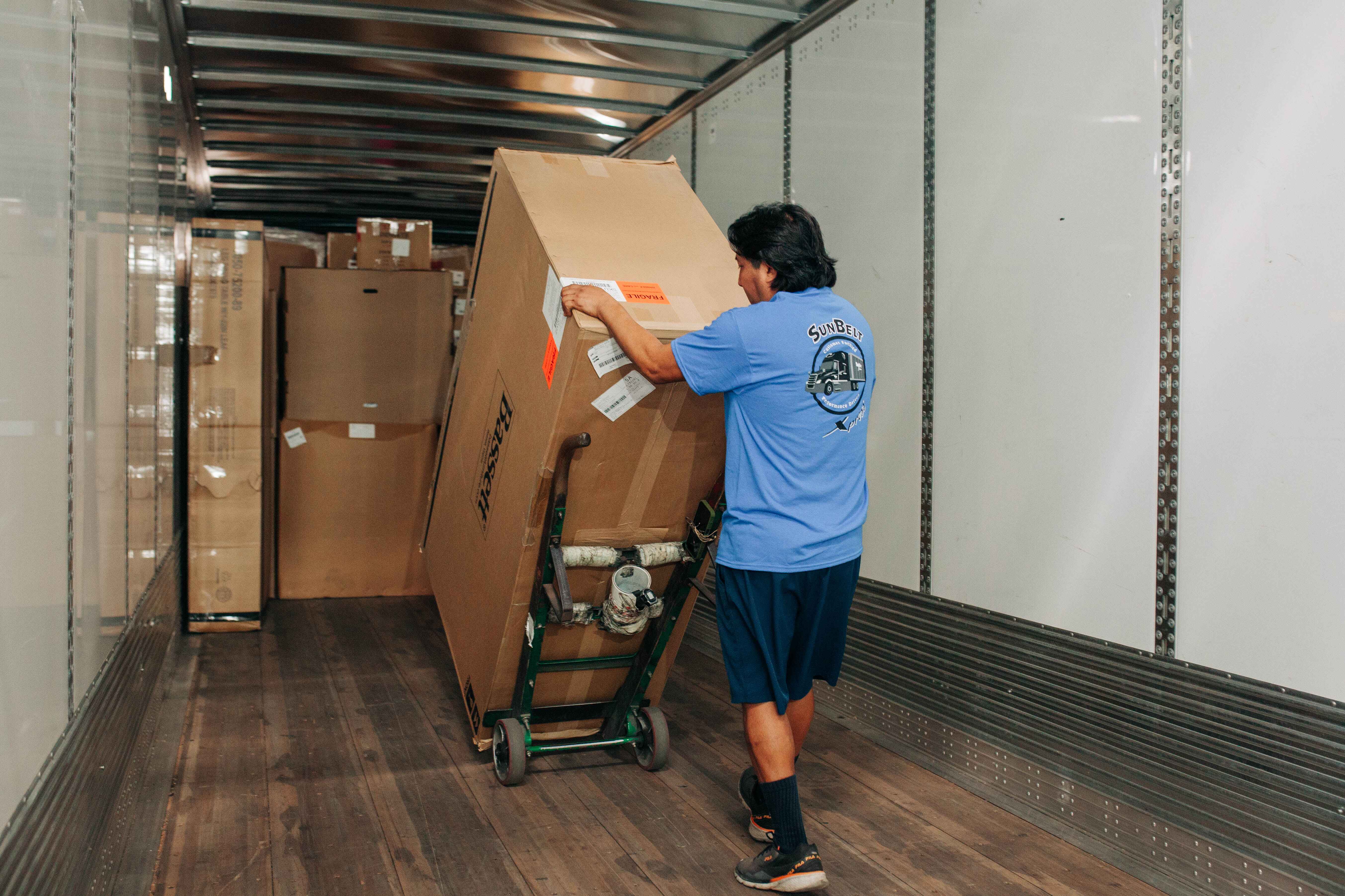 man-unloading-boxes-off-a-SunBelt-Xpress-truck