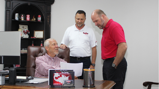 SunBelt team members discussing business at office desk