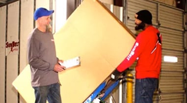 SunBelt employees working in warehouse moving large box